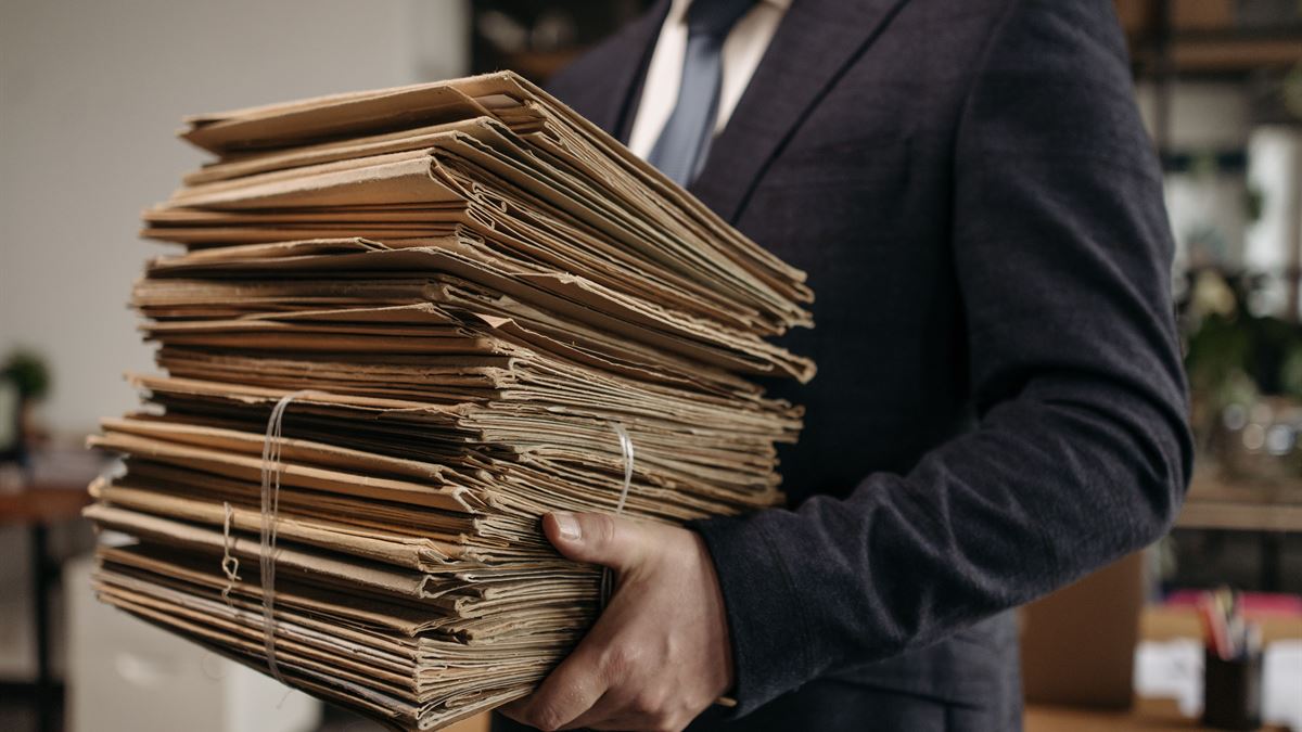 Kucağında bağlanmış dosya destesi taşıyan ofis çalışanı